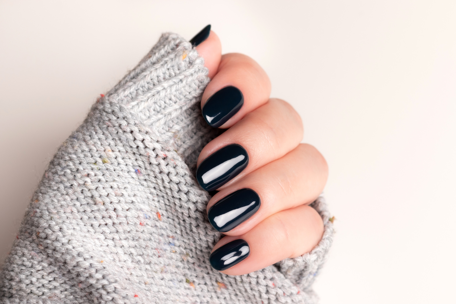Female hand with beautiful manicure - black nails. Nail care